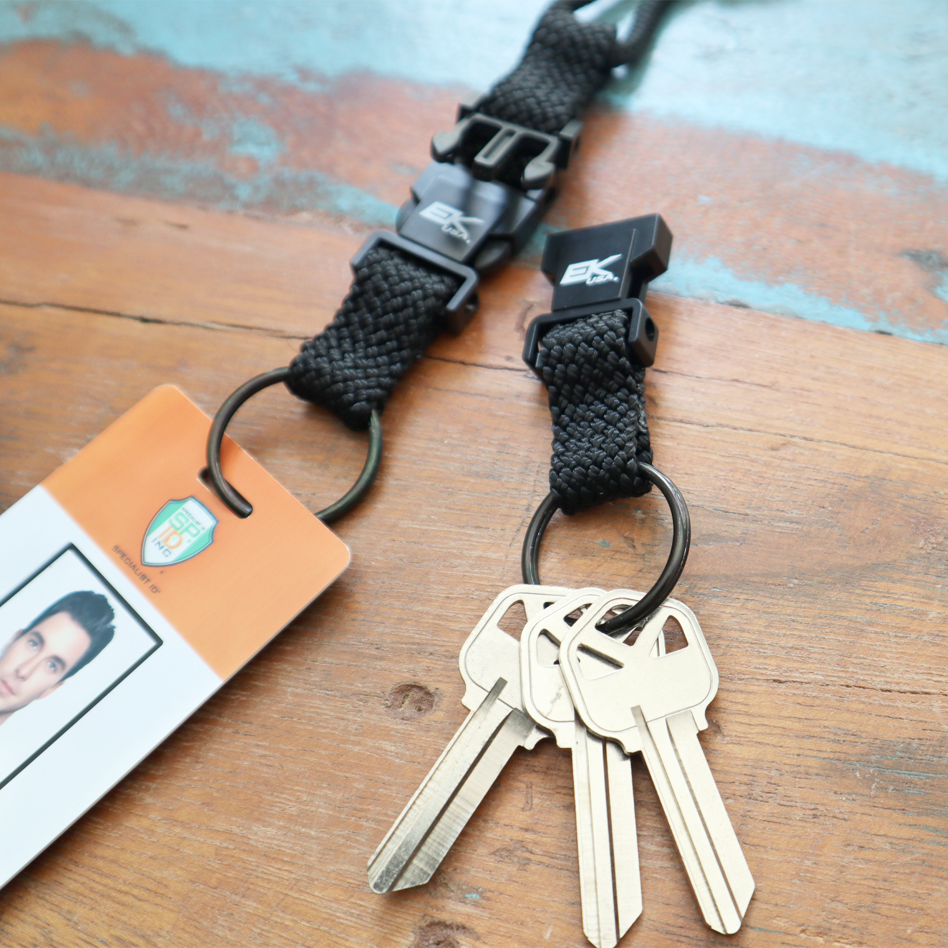 The EK Black Lanyard With Two Detachable Key Rings (10046) by EK USA securely holds a photo ID card and keys with its durable nylon braid.