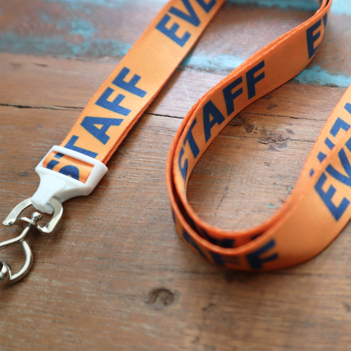 An ideal choice for event staff, this orange "Event Staff" breakaway flat lanyard features a swivel hook.