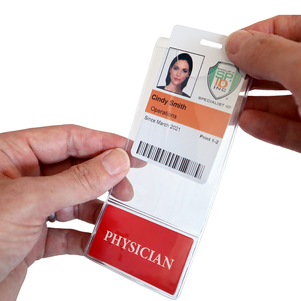 A person holds an ID badge for Cindy Smith from Operations, displaying her photo, barcode, and "Since March 2021." A red "PHYSICIAN" card is visible in an ID badge holder below the badge. Customizable titles on PHYSICIAN BadgeBottom Badge Holder & Badge Buddy IN ONE!! - Vertical ID Badge Sleeve with Bottom Role Tag for Doctors add a professional touch.