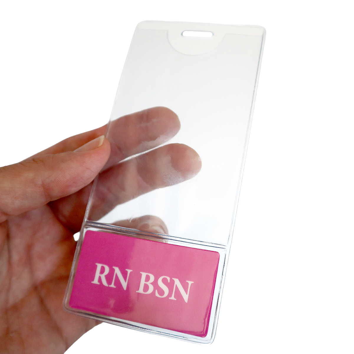 A hand holds a clear RN BSN BadgeBottom Badge Holder & Badge Buddy IN ONE!! - Vertical ID Badge Sleeve with Bottom Role Tag for Registered Nurses with a pink card that reads "RN BSN" at the bottom.