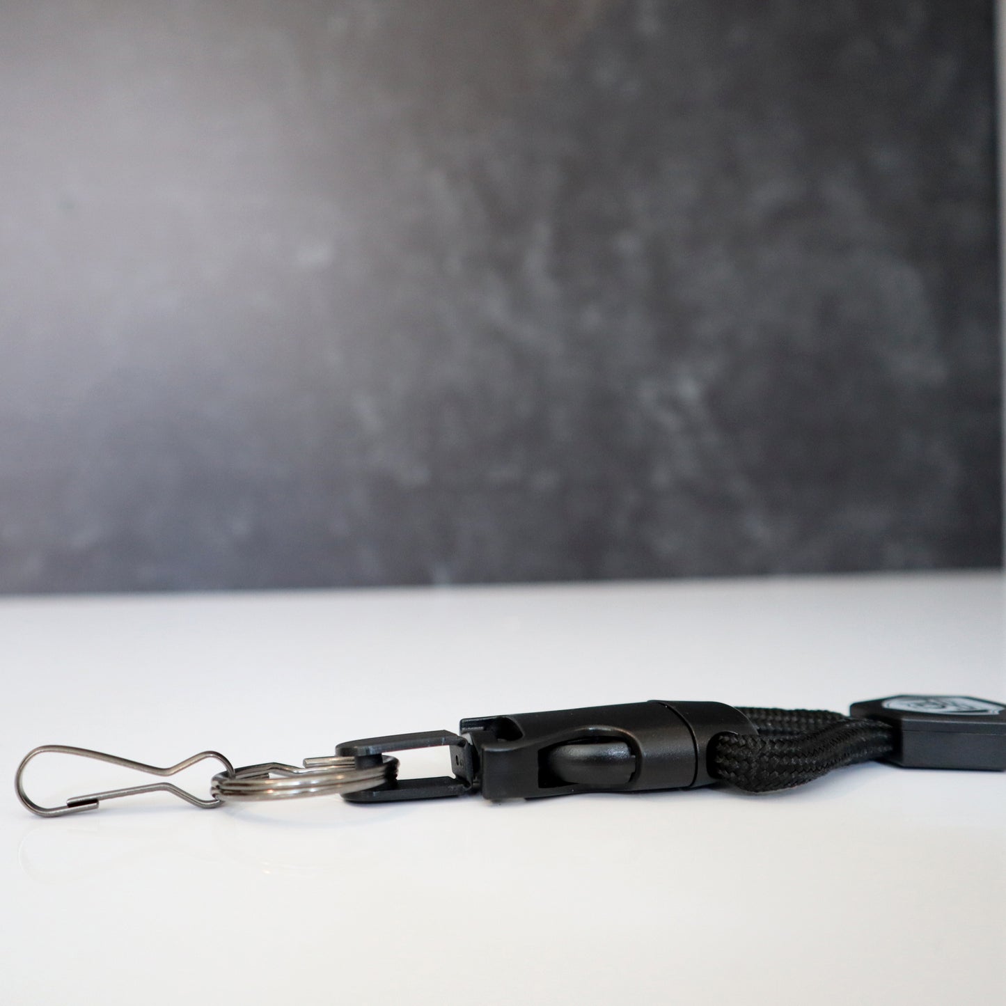 A Heavy Duty Breakaway Lanyard for ID Badges & Keys (SPID-2460), featuring a metal clip and detachable key ring, lies on a white surface.