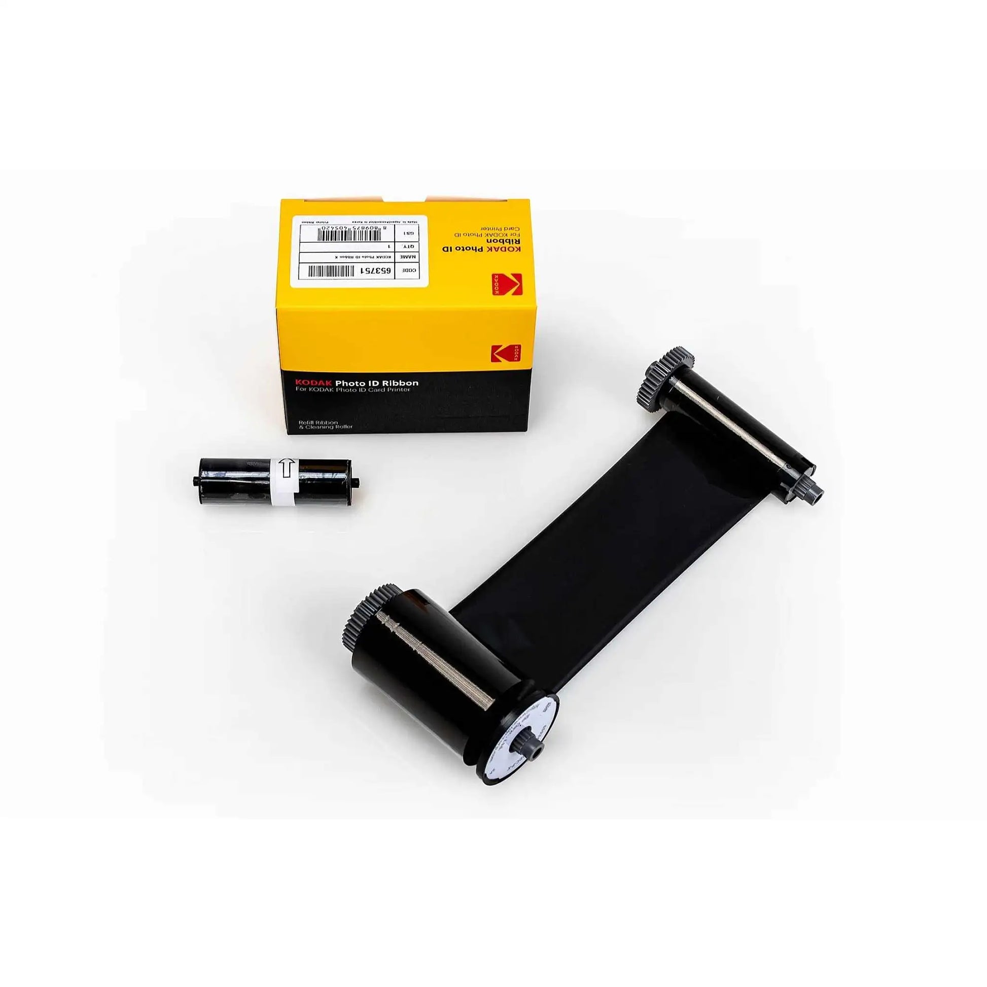 The Kodak 653751 Monochrome K Ribbon, designed for up to 1200 prints and compatible with ID100S and ID200S ID card printers, is showcased with its packaging box. Alongside the monochrome ribbon, one label roll and one film roll specifically engineered for ID card printers are also displayed.