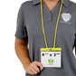 Person wearing a gray polo shirt with a Specialist ID logo, holding a 4x3 Inch Color Bar Event Badge with Adjustable Lanyard - Extra Large (Max Insert 4 3/8 X 3 1/2) Colored Name Badge with Matching Color Code Lanyard (1860-290X). The badge displays the dimensions 4 1/2" x 3 5/8".