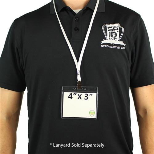 A person in a black polo shirt with the "Specialist ID Inc" logo wears a Clear 4X3 Horizontal Convention Size Badge Holder (406-J-CLR) on a white lanyard around their neck. The text below states "*Lanyard Sold Separately".